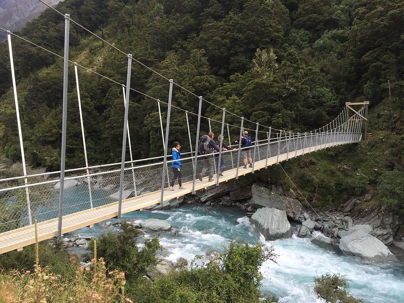 hiking in mount aspiring national park with swing bridge of the matukituki river